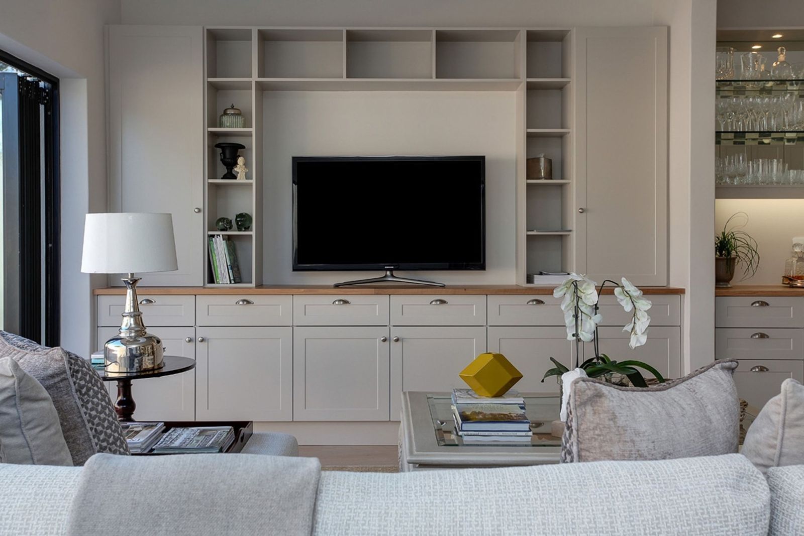 Media wall with open shelving around a TV and a wood-topped lower cabinet run (example style photo)
