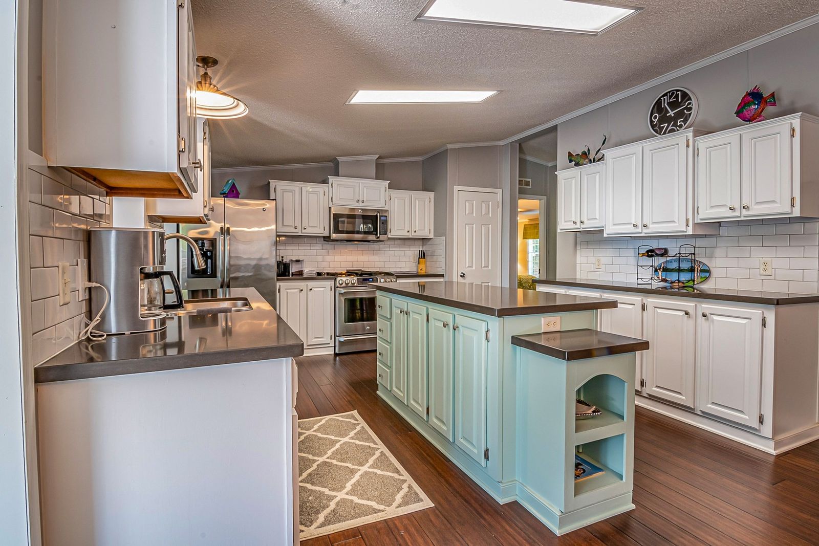 White kitchen cabinets with a painted island featuring open end shelves (example style photo)
